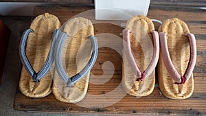 Top view of beautiful two pairs weave shoes on wooden shelf for background