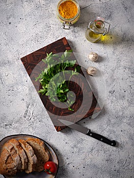 Top view of a beautiful wooden cutting board on a table background with bread, vegetables and spices