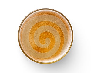 Top view of beer bubbles in glass cup on white background