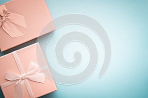 Top view beige gift boxes with ribbons tied with a bow on a light blue background in pastel colors
