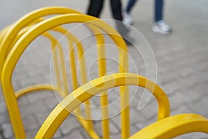 Top view of the bicycle parking lot, next to the legs. Yellow metal close-up with space to copy