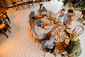 Top view of big family clinking glasses during traditional Christmas dinner