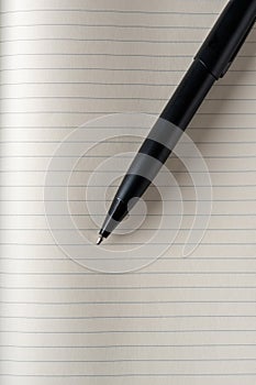 Top view of black ballpoint pen on lined note paper