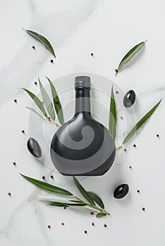 top view of black bottle of olive oil and olives