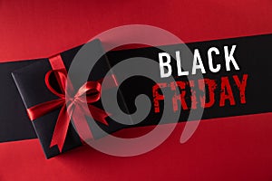 Top view of black christmas boxes with red ribbon on black background with copy space for text. black Friday and Boxing Day