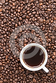 Top view of black coffee cup on coffee beans background