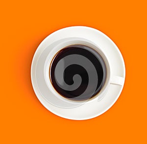 Top view of black coffee cup on orange