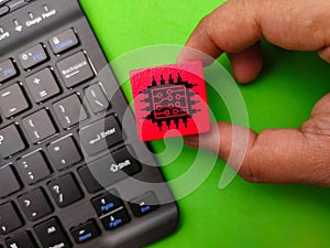 Top view black keyboard with hand holding colored block and microchip icon