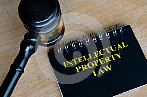 Top view of black notebook with text Intellectual Property Law and with gavel background