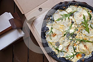 Top view black quattro formaggi pizza in box