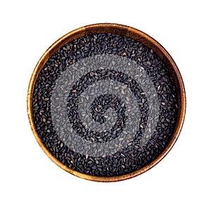 Top view of black sesame seeds in the round wooden bowl for cooking isolated on white background.