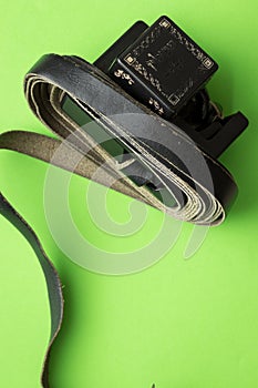 Top view of black strips of tefillin on a green background