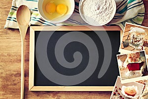 Top view of blackboard and wooden spoon over wooden table and collage of photos with various food and dishes.