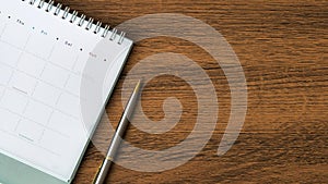 The top view blank calendar with a pen on desk