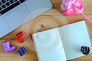 Blank diary notebook and personal computer laptop with Christmas and New Year ornaments and decoration on wooden table