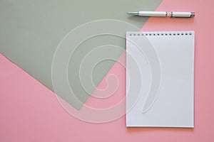 Top view of blank note paper with pen on pink background