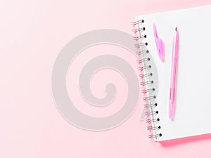 Top view of blank note with pen on pink background