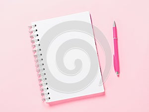 Top view of blank note with pen on pink background