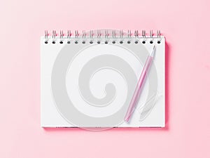 Top view of blank note with pen on pink background