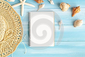 Top view of blank notebook on blue wood table, sea shells and starfish on a blue wooden background, Summer concept