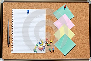 Top view of blank notebook on cork board with pen, note and colo
