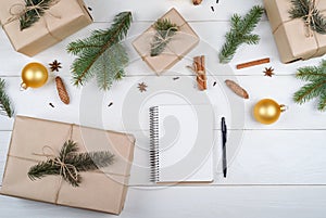Top view of blank notebook for template design on white wooden background with xmas decorations, copy space. Christmas background.