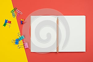 Top view of blank open notebook with pencil and stationery items