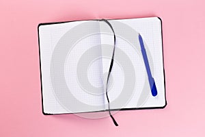 Top view of blank open notebook on pink background, concept of education or new workplace