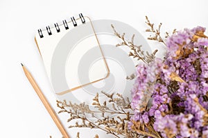 Top view of a blank paper note with pencil and flower bouquet