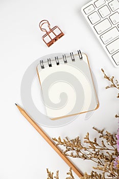 Top view of a blank paper note with pencil and flower bouquet