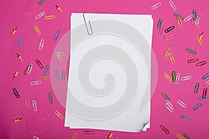Top view of blank white papers and colorful paper clips