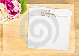 Top view of Blank wooden plate with white menu card and flower pot