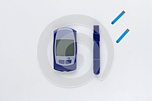 Top view of blood glucose meter, lancet and test strips on the white background