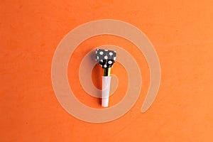 Top view of blowout whistle isolated on an orange background