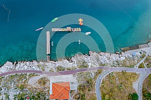 Top view of the blue Adriatic sea, catamarans in the sea, Stone beach near the sea with a walking path.