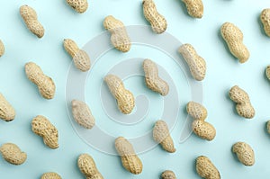 Top view of blue background and raws of peanuts on it