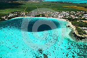 Top view of the Blue Bay lagoon of Mauritius. A boat floats on a turquoise lagoon