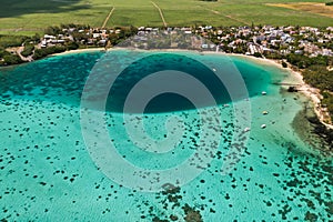 Top view of the Blue Bay lagoon of Mauritius. A boat floats on a turquoise lagoon