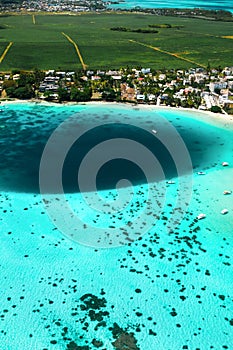 Top view of the Blue Bay lagoon of Mauritius. A boat floats on a turquoise lagoon