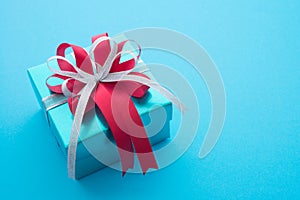 Top view of blue gift box with red white bow ribbon on blue background and copy space. Credit card reward point, cash back, bonus