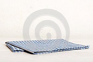 top view with blue kitchen napkin isolated on table background. Folded cloth for mockup with copy space, Flat lay