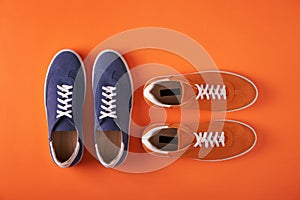 Top view of blue and orange suede sneakers on orange background