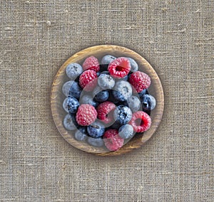 Top view. Blue and red berries in bowl. Ripe raspberries and blueberries. Background of mix berries with copy space for text.