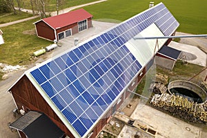 Top view of blue solar photo voltaic panels system on wooden building, barn or house roof. Renewable ecological green energy