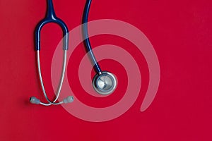 Top view blue stethoscope on red background. For check heart or health check up concept.