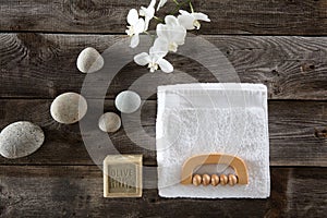 Top view, bodycare concept with soap, towel, pebbles and flowers