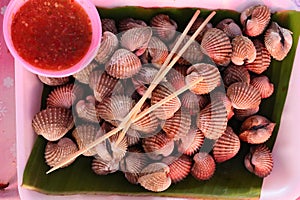 Top view, boiled cockles, seafood in foam cups with spicy dipping sauce.