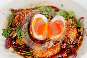 Top view boiled and fried duck eggs with tamarind sauce Garnish with dried chilies, fried shallots and coriander