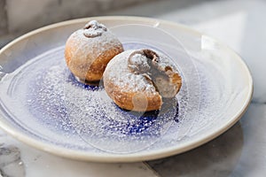 Top view of Bombolone is an Italian filled doughnut and is eaten as a snack food and dessert with hands cutting