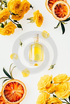 top view of bottle of perfume with beautiful flowers around